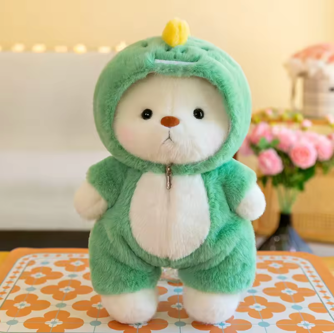 Plush bear dressed in a green dinosaur onesie